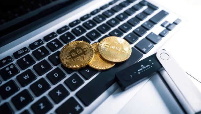 A hardware wallet and laptop, symbolizing secure cryptocurrency storage.