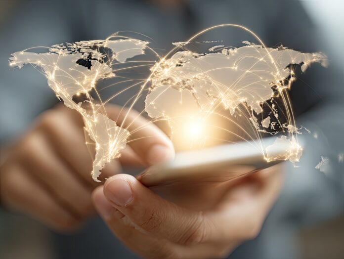 A person using a smartphone with digital connection lines across a world map