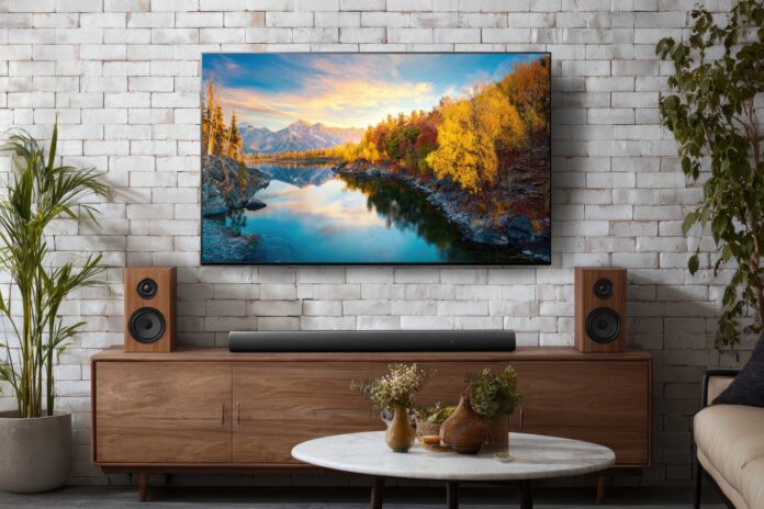 A modern living room setup featuring the LG G4 OLED Evo TV on a wall.