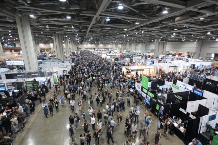 Wide shot of exhibit hall at TechCrunch All Stage with startup tables and visitors