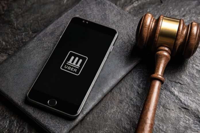 Smartphone with Uber app icon beside a judge’s gavel