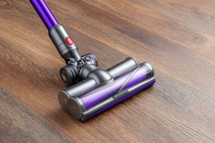 Dyson Humdinger handheld vacuum on a hardwood floor