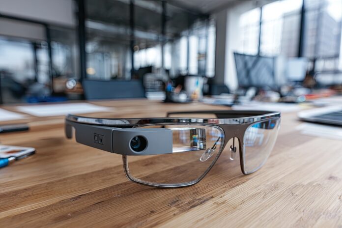 A close-up view of Google Glass Android XR smart glasses on a modern workspace