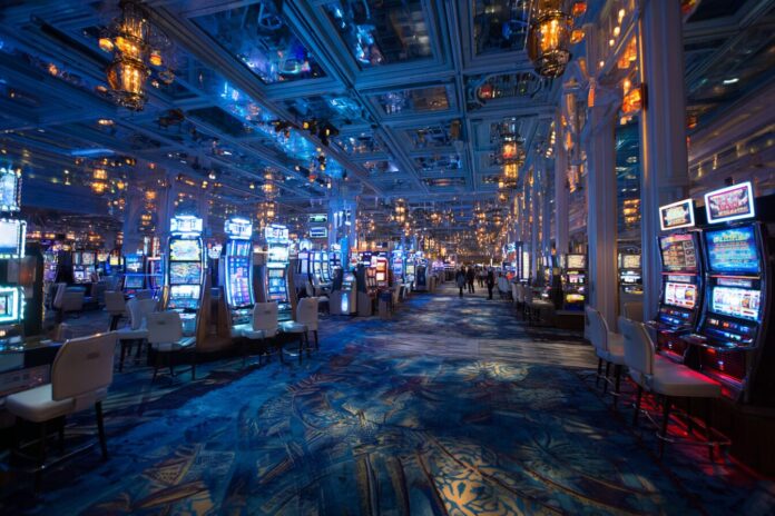 Blue-toned LED lights illuminating a bustling casino floor at night.