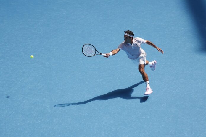 Tennis player hitting a heavily spun topspin forehand with visible ball blur