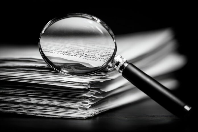 A magnifying glass over a stack of medical research papers, highlighting errors and inconsistencies.