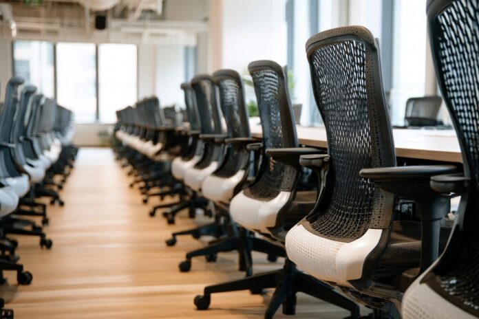 Row of office chairs, with some empty and others filled, highlighting AI talent retention at OpenAI and across Silicon Valley
