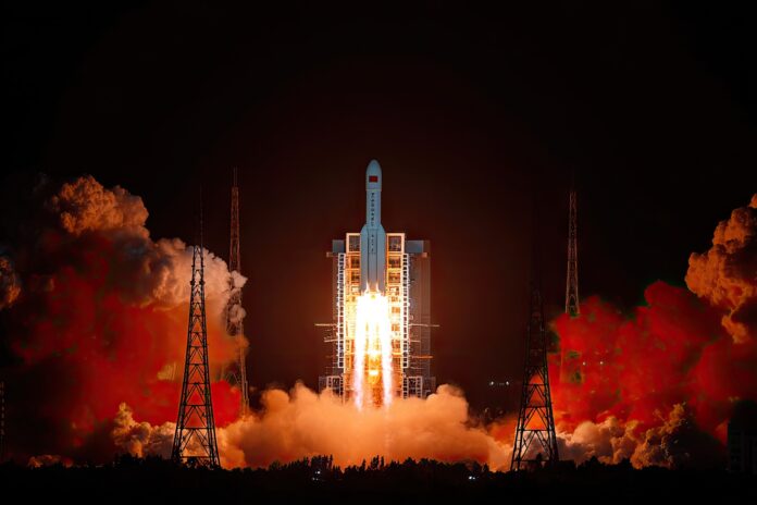 China's Tianwen 2 spacecraft lifting off from its launch pad at night, with the rocket's engines illuminating the scene.