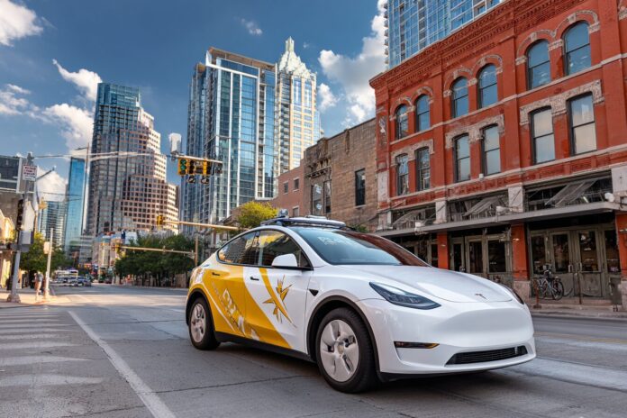 Tesla Model Y robotaxi on Austin street with distinctive logo
