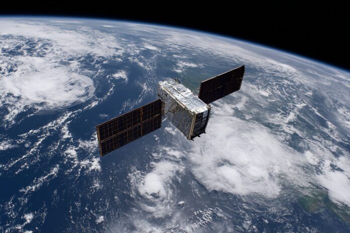 NASA's Terra satellite, orbiting Earth, with a backdrop of clouds and continents.