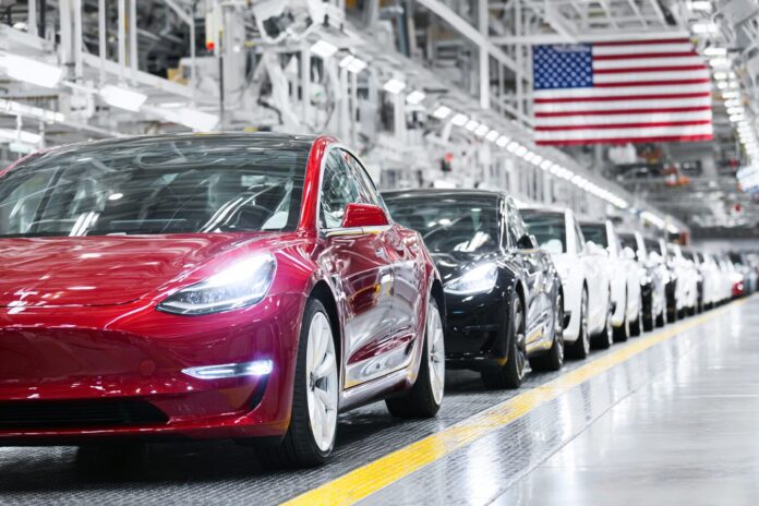 A lineup of Tesla vehicles in an American factory setting