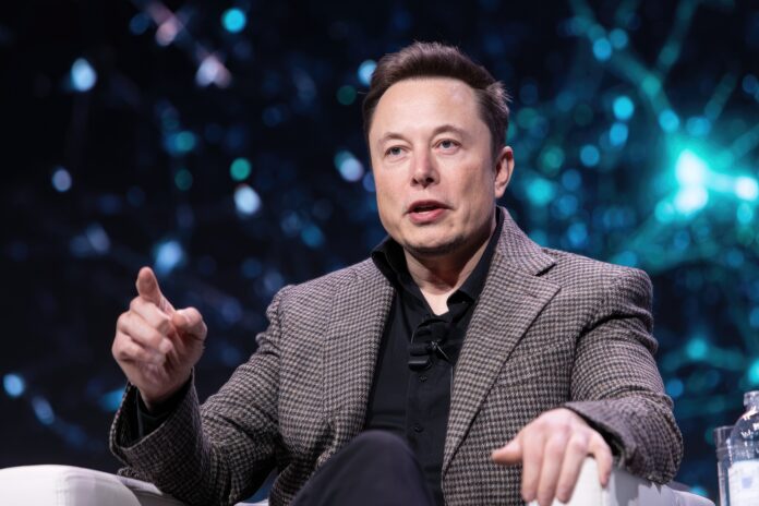 Elon Musk speaking at a conference about xAI and artificial intelligence.