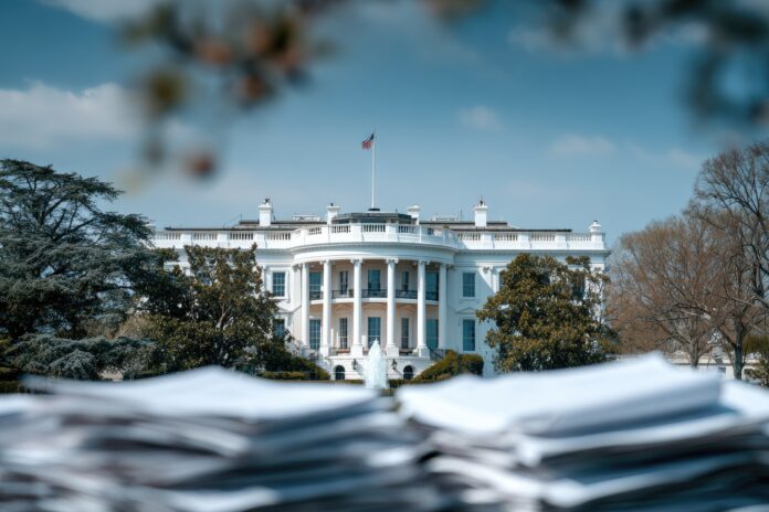 White House with Executive Order papers in foreground, symbolizing pivotal federal policy changes.