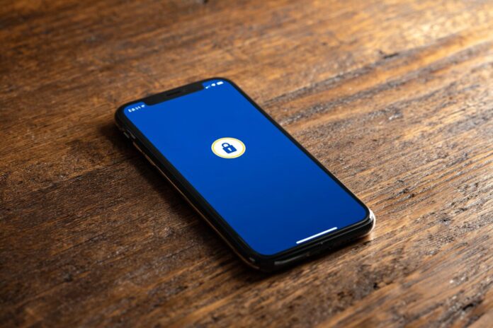 A smartphone showing the Coinbase app with an unlocked account symbol.