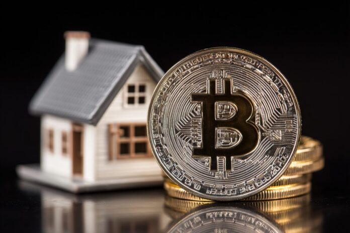 Bitcoin digital coin placed next to a miniature real estate house model, representing property purchase with cryptocurrency.