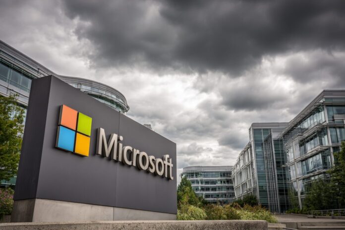 Microsoft headquarters sign with modern campus buildings and cloudy sky in Redmond, symbolizing major corporate decisions.