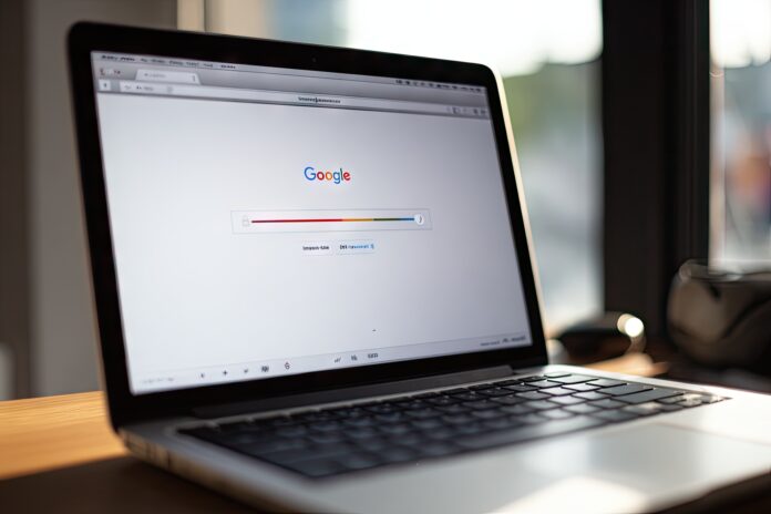 A laptop screen displays a sluggish Gmail inbox, with a slow loading bar.