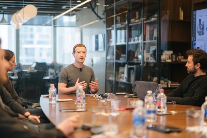 Mark Zuckerberg in Meta headquarters discussing AI strategy with new hires.