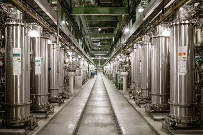 Uranium enrichment centrifuge facility highlighting rows of spinning cylinders.