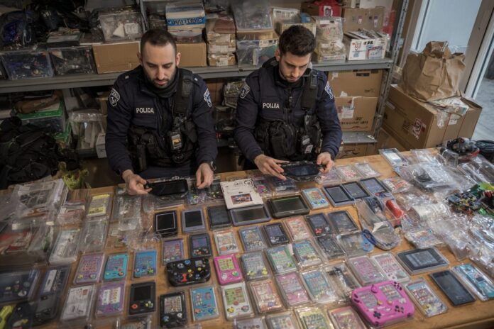 Italian police officers confiscating gaming handhelds from a YouTuber's home.