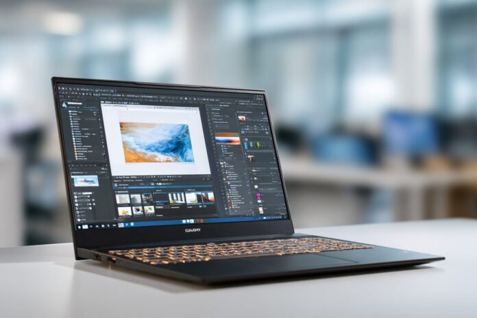 Slim GIGABYTE AI laptop open on a clean office desk, showing its lightweight profile and screen displaying a creative app.
