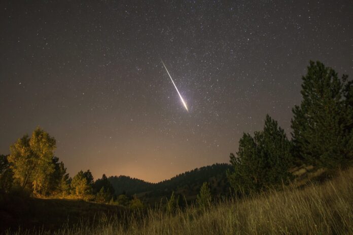 A meteor streaking through Earth's atmosphere during the night, symbolizing a rare interstellar meteor event.