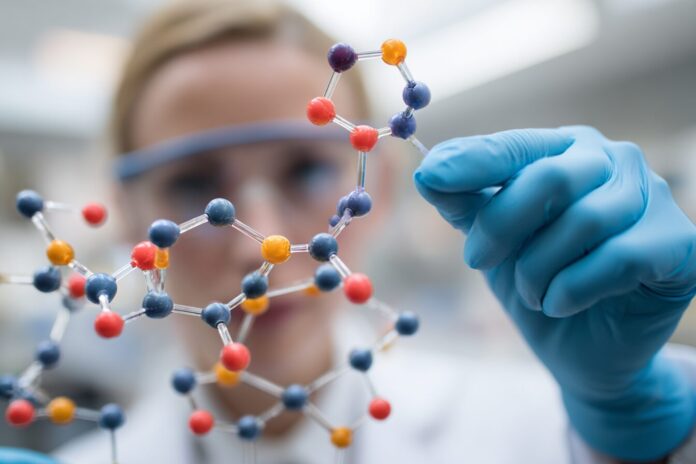 Research scientist examining molecular structure of new experimental weight loss drug in laboratory setting.