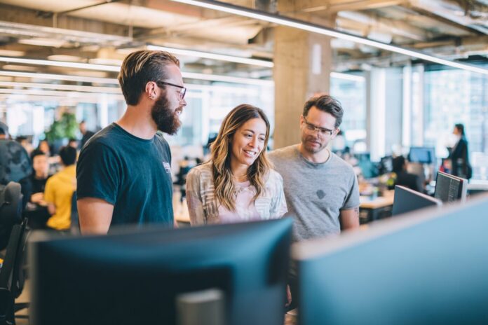 Anthropic team collaborating in a modern office, discussing AI development strategy.