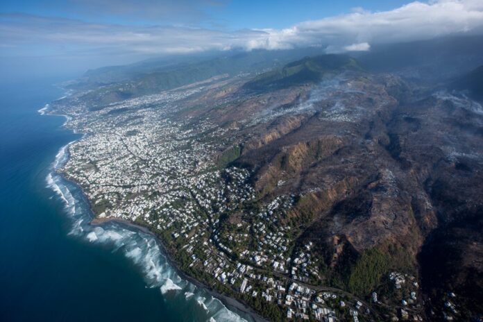 Aerial view of Reunion Island showing dense urban areas and coastal vegetation. This region has experienced significant Chikungunya outbreaks in 2025.