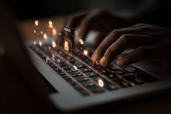 Hands on MacBook keyboard, screen with Spotlight search, overlay of data exfiltration icons
