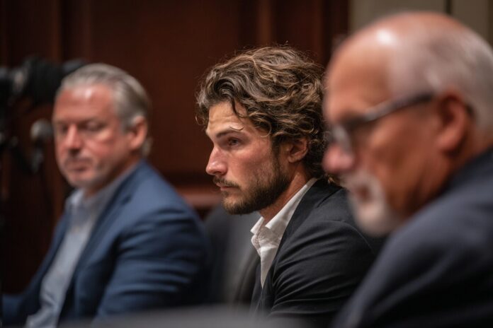 Roman Storm, co-founder of Tornado Cash, seated in a courtroom, looking concerned as his lawyers confer.