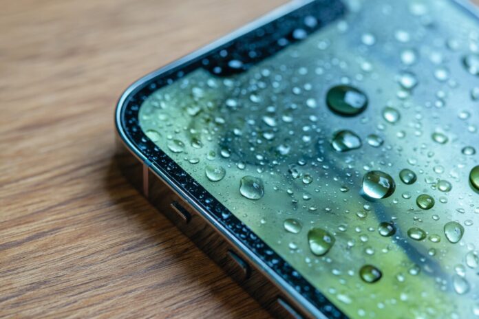 A closeup of an iPhone showing the new Liquid Glass transparency effects in iOS 26 beta 4.