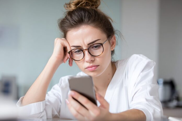 A concerned patient looking at a smartphone showing a healthcare chatbot interface
