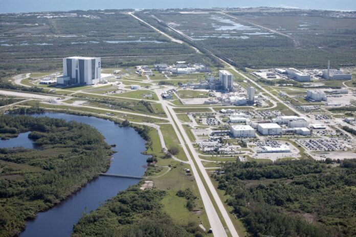 Aerial view of Kennedy Space Center facilities with utility lines visible.