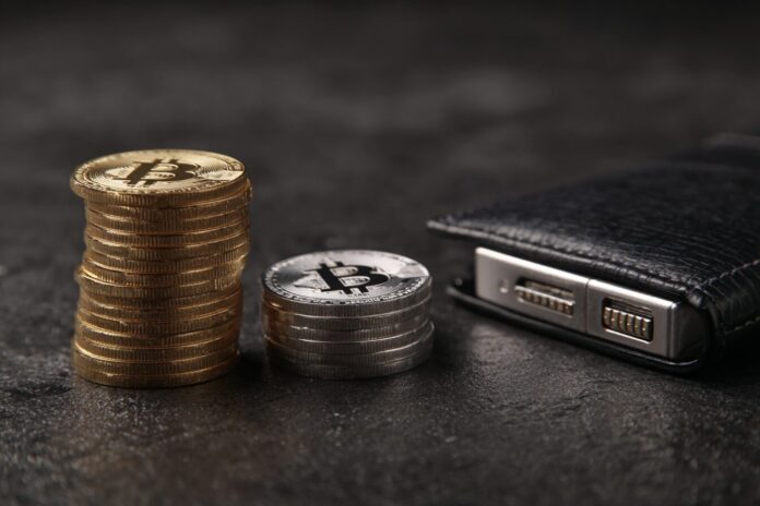 Stack of cryptocurrency coins and a secure cold wallet device on a dark background