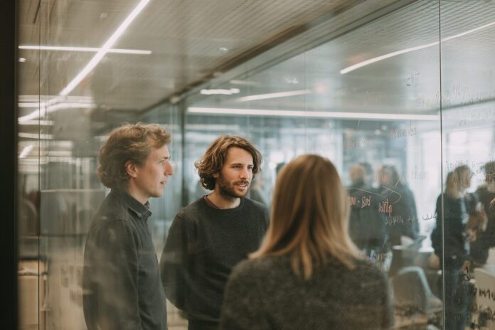 Mistral AI team in discussion at modern Paris office, reflecting innovation and growth.