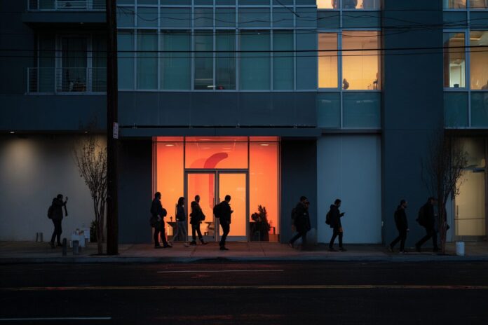OpenAI headquarters in San Francisco with employees leaving the building at dusk