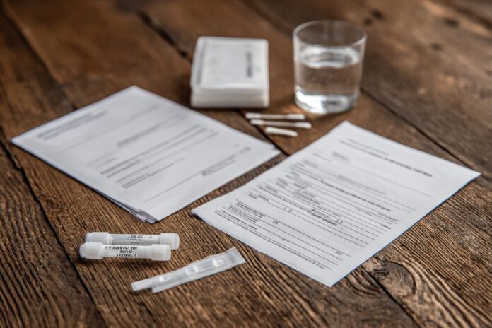 Police DNA sample kit with papers and swabs on a table.