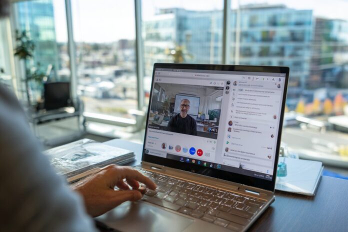 Person using Google Meet voice translation on a laptop in an office setting.