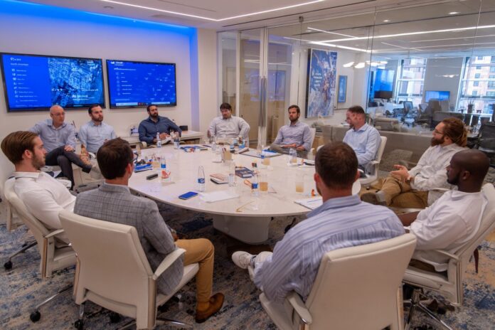 SEC officials and startup founders engage in group discussion at a roundtable event in a modern conference room.