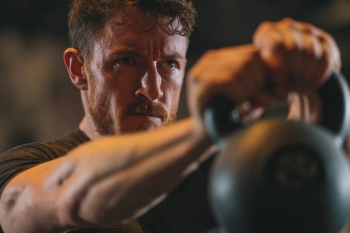 Person with correct kettlebell swing form, focused and safe.