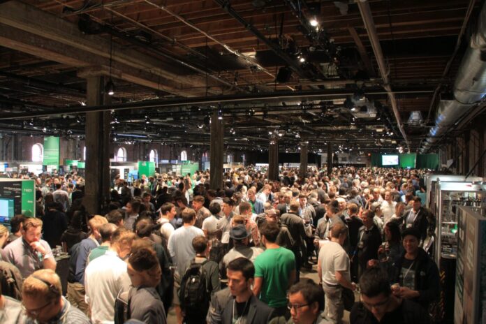 Buzzing crowd of founders and investors gathering at TechCrunch Disrupt, with 200 startup booths.