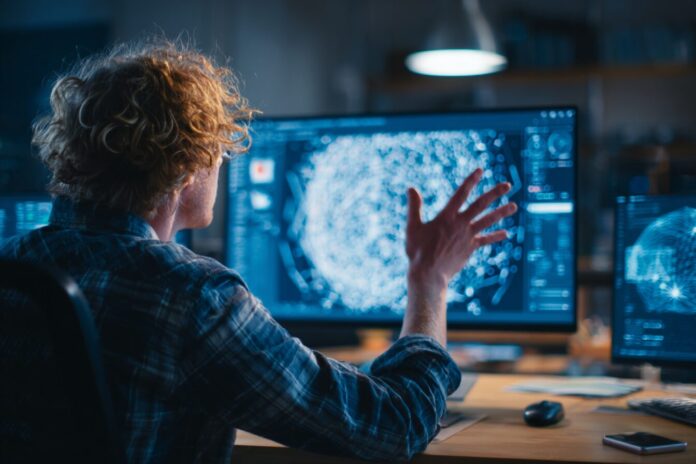 A developer interacting with a digital AI agent while designing a video game on a computer.