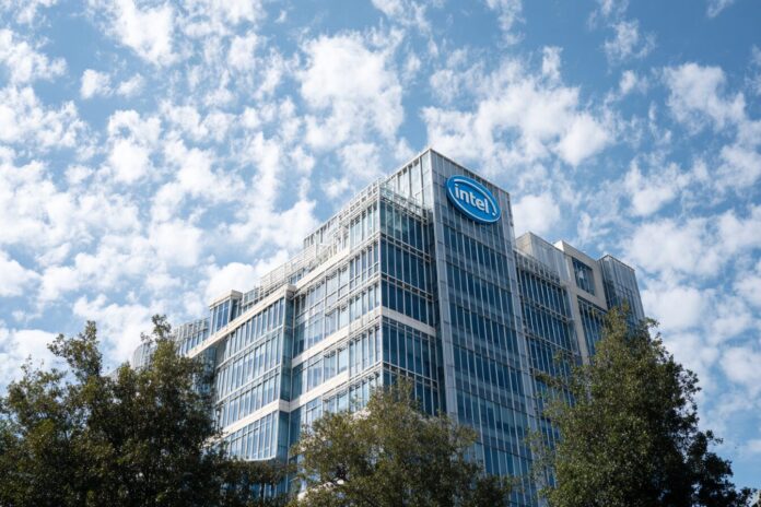 Intel headquarters building with company logo visible, sunny sky backdrop.