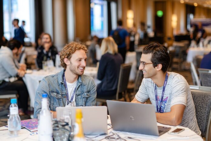 Meta and Midjourney teams collaborating at a conference, discussing AI visual technology.