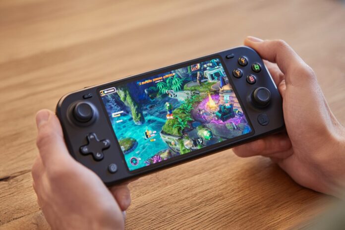 Abxylute 3D One handheld on a table displaying a vibrant game scene in 3D, without glasses.