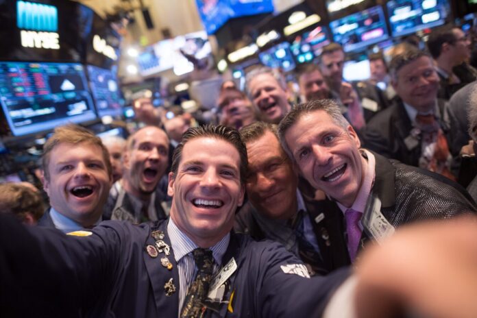 Bullish NYSE floor celebratory IPO moment, showing traders and digital screens