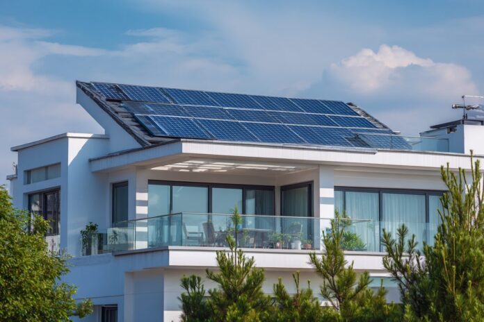 A modern home with rooftop solar panels, emphasizing their integration into the local power grid.