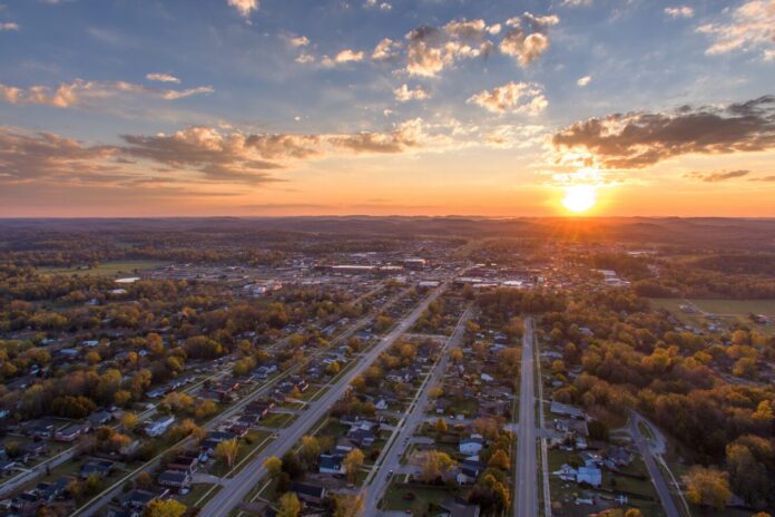 Aerial view of Bowling Green, Kentucky at sunset with neighborhoods and roadways showing growth.