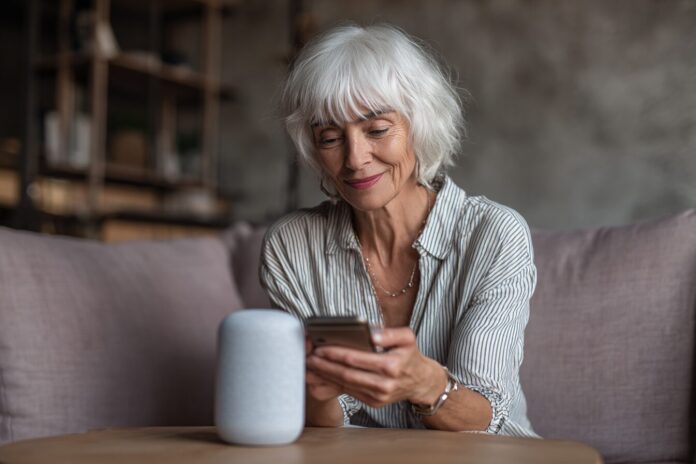 Older woman using a smart speaker at home